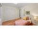 Bedroom with wood-look flooring, closet, twin bed, and a bedside table at 1403 Meadow Ln, Chapel Hill, NC 27516