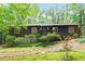 Charming single-story home with wooded surroundings and inviting front porch with green door at 1403 Meadow Ln, Chapel Hill, NC 27516