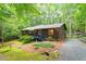 Exterior view of house surrounded by green trees with a gravel driveway and lush landscaping at 1403 Meadow Ln, Chapel Hill, NC 27516