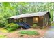 Charming exterior view of home with lush landscaping, wood siding, and a blue painted porch and trim at 1403 Meadow Ln, Chapel Hill, NC 27516