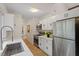 Bright kitchen featuring stainless steel appliances, white cabinetry, and wood-look floors at 1403 Meadow Ln, Chapel Hill, NC 27516