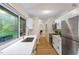 Bright kitchen featuring stainless steel appliances, white cabinetry, and a large window overlooking the backyard at 1403 Meadow Ln, Chapel Hill, NC 27516