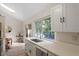 Updated kitchen with quartz counters, white cabinets, stainless appliances and a large window above the sink at 1403 Meadow Ln, Chapel Hill, NC 27516