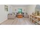 Well-lit living room featuring a large sectional sofa, stylish decor, and light hardwood flooring at 1403 Meadow Ln, Chapel Hill, NC 27516