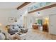 Open concept living room with vaulted ceilings, exposed beams, and a dining area with lots of natural light at 1403 Meadow Ln, Chapel Hill, NC 27516