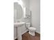 Cozy powder room featuring pedestal sink, modern fixtures and a decorative mirror at 1434 Salem Dr, Apex, NC 27502