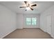 Neutral bedroom with standard carpet, two windows and ceiling fan at 1434 Salem Dr, Apex, NC 27502