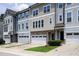 Charming townhome exterior featuring a two-car garage, brick accents, and manicured lawn at 1434 Salem Dr, Apex, NC 27502