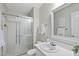 Bathroom featuring a shower with glass doors, white sink, and neutral decor at 1500 Laureldale Dr, Raleigh, NC 27609