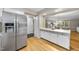Open concept kitchen with stainless steel refrigerator and view into the dining and living area at 1500 Laureldale Dr, Raleigh, NC 27609