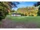 Lush green backyard surrounded by tall trees, creating a private and peaceful outdoor space for relaxation at 1515 Bradsher Dr, Stem, NC 27581
