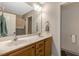 Bathroom with double sinks, wood cabinets, tile floors, and a mirror with light at 1515 Bradsher Dr, Stem, NC 27581