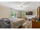 This bedroom includes a ceiling fan, a large window for lots of natural light, and vinyl wood-look floors at 1515 Bradsher Dr, Stem, NC 27581
