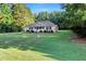 Charming single-story home with a welcoming front porch, well-maintained lawn, and lush surrounding trees at 1515 Bradsher Dr, Stem, NC 27581