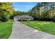 Charming single-story home with a manicured lawn, mature trees, and a long driveway at 1515 Bradsher Dr, Stem, NC 27581