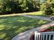 Well-maintained front yard with lush lawn, mature trees, and a paved driveway leading to the house at 1515 Bradsher Dr, Stem, NC 27581