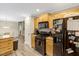 Kitchen with dark appliances, wooden cabinets, and a view into the living room at 1515 Bradsher Dr, Stem, NC 27581