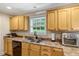 Well-lit kitchen with neutral countertops, wooden cabinetry and a double sink at 1515 Bradsher Dr, Stem, NC 27581