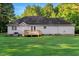 View of the rear exterior featuring a well-maintained yard and back deck at 1515 Bradsher Dr, Stem, NC 27581