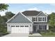 Charming two-story home with stone accents, gray siding, and a two-car garage in a landscaped yard at 20 Malbec Way, Youngsville, NC 27596