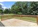 Outdoor wooden deck showcasing a tranquil view of the landscaped backyard and surrounding greenery at 21 Cambridge Dr, Angier, NC 27501