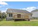 Rear exterior view of the home featuring a deck overlooking the grassy backyard at 21 Cambridge Dr, Angier, NC 27501
