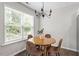 Inviting dining area with a round wooden table, four chairs, and ample natural light from the large window at 21 Cambridge Dr, Angier, NC 27501