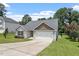 An inviting one-story home with a two-car garage, driveway and lush green lawn under a partly cloudy sky at 21 Cambridge Dr, Angier, NC 27501