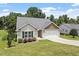 Attractive one-story home with a two-car garage, manicured lawn, and mature trees adding to its curb appeal at 21 Cambridge Dr, Angier, NC 27501