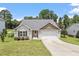Charming single-story home with a well-manicured lawn and two-car garage, complemented by mature trees at 21 Cambridge Dr, Angier, NC 27501