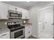 Well-lit kitchen with stainless steel appliances and adjacent laundry room, with tile floor at 21 Cambridge Dr, Angier, NC 27501