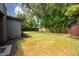 Expansive backyard showcasing lush green grass and mature trees, offering a serene and private outdoor space at 2129 Ridge Rd, Raleigh, NC 27607