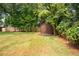 Backyard featuring a wooden shed, providing practical storage solutions within a private, fenced yard at 2129 Ridge Rd, Raleigh, NC 27607