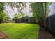 Beautiful backyard featuring lush green grass, mulch beds, and mature trees at 2129 Ridge Rd, Raleigh, NC 27607