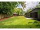 Well-maintained backyard with lush green grass, wooden shed, and modern home at 2129 Ridge Rd, Raleigh, NC 27607