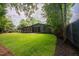 Spacious backyard featuring a well-maintained lawn, privacy fence, and mature trees, perfect for outdoor enjoyment at 2129 Ridge Rd, Raleigh, NC 27607