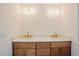 Bathroom vanity featuring double sinks, quartz countertop, wood cabinetry, and modern fixtures at 2129 Ridge Rd, Raleigh, NC 27607