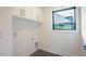 Bright laundry room featuring upper cabinets, tile floor, and a window at 2129 Ridge Rd, Raleigh, NC 27607