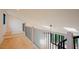 Inviting loft area with wood floors and modern railings, overlooking a living space with skylights at 2129 Ridge Rd, Raleigh, NC 27607