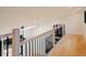Open loft area with wood floors and a modern railing overlooking the living space at 2129 Ridge Rd, Raleigh, NC 27607