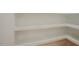 A custom designed walk-in pantry with white shelving and light hardwood floors at 2129 Ridge Rd, Raleigh, NC 27607