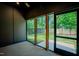 Covered patio with stained concrete floor and large windows offer view of the landscaped yard at 2129 Ridge Rd, Raleigh, NC 27607