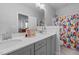 Stylish bathroom featuring a double sink vanity, bright lighting, and a colorful shower curtain at 217 Tumbling River Dr, Wendell, NC 27591