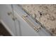 Close-up shot of the white cabinetry featuring granite countertops and elegant brass hardware at 217 Tumbling River Dr, Wendell, NC 27591
