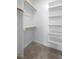 Bright, walk-in closet featuring built-in shelving and wooden rods for ample storage and organization at 217 Tumbling River Dr, Wendell, NC 27591