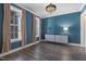 Chic dining room features dark blue walls, hardwood floors, and ample natural light from large windows at 217 Tumbling River Dr, Wendell, NC 27591