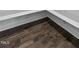 Close up of the dark brown hardwood flooring and white trim in the corner of a room at 217 Tumbling River Dr, Wendell, NC 27591