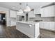 Bright kitchen features an island with granite countertops, stainless appliances, white cabinets and modern pendant lighting at 217 Tumbling River Dr, Wendell, NC 27591