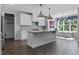 Well-lit kitchen with a central island, white cabinets, and modern pendant lights at 217 Tumbling River Dr, Wendell, NC 27591