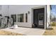 Outdoor patio with a modern design, white siding, dark door, and sleek patio furniture at 2201 Millbank Village Ct # 101, Raleigh, NC 27610